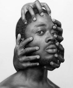 a black and white photo of a man with hands on his face