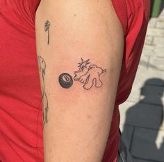 a woman with a tattoo on her arm is holding a pool ball in one hand