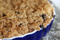 a close up of a pie in a blue dish on a counter top with crumbs