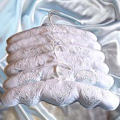 four pairs of white gloves on a silver cloth