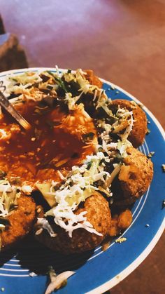 a blue plate topped with fried food covered in sauce