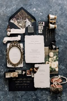 the wedding stationery is laid out on top of the table, including an antique mirror and other personal items