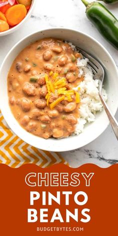 a white bowl filled with beans and rice on top of a table next to vegetables