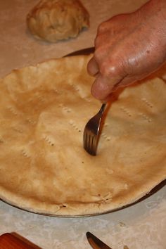 a person with a fork in their hand and some food on the table