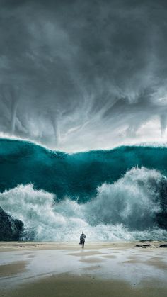 a man standing on the beach in front of an ocean wave with dark clouds above