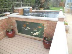 a hot tub sitting on top of a wooden deck next to potted planters