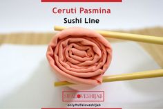 two yellow chopsticks are laying on top of a pink cloth with the words ceruti pasmina sushi line