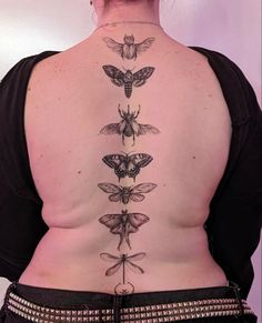 the back of a woman's body with moths on it