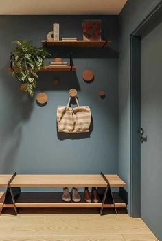 a wooden bench sitting under a potted plant next to a wall mounted shoe rack