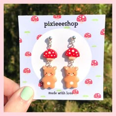 a pair of earrings that are shaped like bears and mushrooms with polka dots on them