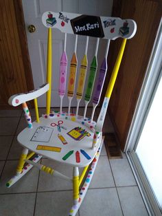 a child's rocking chair decorated with markers and crayons on the seat