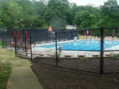 a fenced in swimming pool surrounded by trees