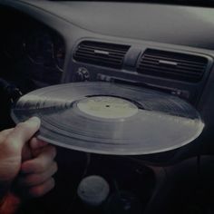 a person holding a record in their hand while sitting in the driver's seat