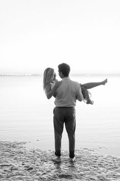 a man carrying a woman on his back at the beach