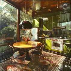 a kitchen with a table and chairs next to a stove top oven in front of a large window