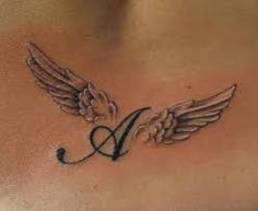 a woman's chest with an angel wing tattoo on it