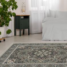 a bedroom with a large rug on the floor and a bed in the corner, next to a potted plant