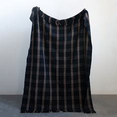 a black and white checkered dress hanging up against a wall with a hole in the back