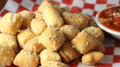 fried food sitting on top of a red and white checkered table cloth