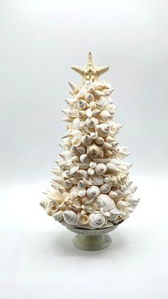 a christmas tree made out of seashells and starfish on a white background