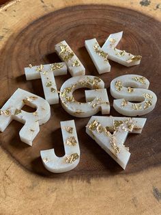 the letters are spelled with gold flecks on top of each other in front of a wooden bowl