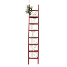 a red ladder with the word believe hanging from it's side, decorated with pine cones and greenery