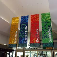 colorful banners hanging from the ceiling above a gym area with machines and exercise equipment in the background