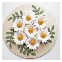 some white and yellow flowers on a wooden plate