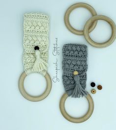 an assortment of knitted items including rings, yarn and buttons on a white surface