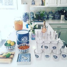 a kitchen counter topped with lots of cups and bowls filled with food next to lemons