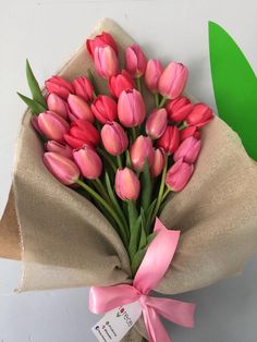 a bouquet of pink tulips wrapped in burlock