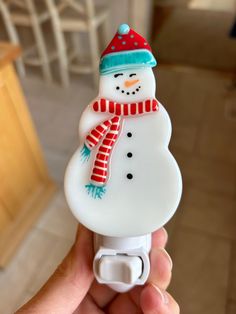 a hand holding a snowman shaped bottle opener