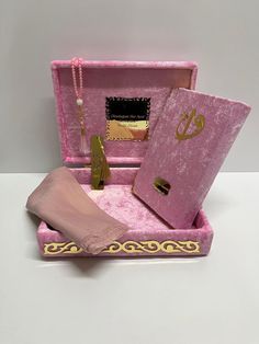 an open pink box with gold accents and accessories