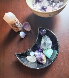 a bowl filled with lots of rocks on top of a wooden table