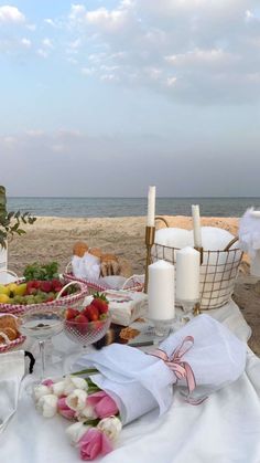 a table with food and candles on the beach