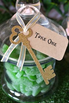 a jar filled with green and yellow candies next to a tag that says take one