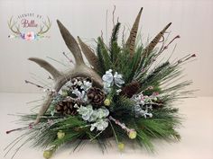 a vase filled with flowers and antlers on top of a table