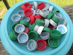 a blue bowl filled with lots of different colored plastic cups on top of a wooden table