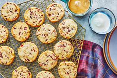 several muffins on a cooling rack next to cups and saucers