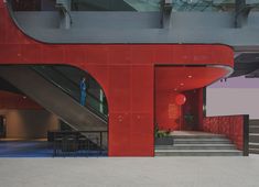 the entrance to an office building with red walls and stairs