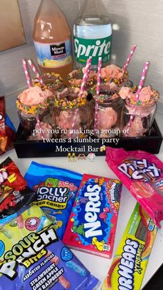 a table topped with lots of candy and candies next to a bottle of soda