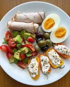 a white plate topped with different types of vegetables and an egg on top of it