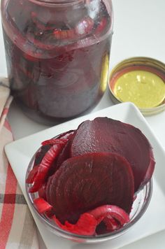 beets in a glass bowl next to a jar of mustard