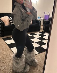 a woman is taking a selfie in the mirror while wearing boots and leggings