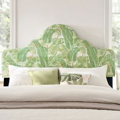 a bed with green and white headboard in a bedroom