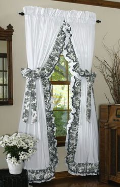 the window is decorated with black and white curtains