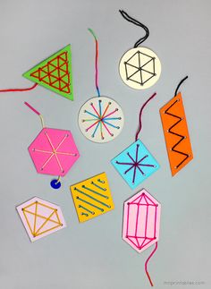 colorful paper ornaments hanging from strings on a gray surface