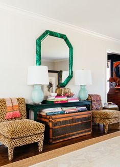 a living room filled with furniture and a large mirror on the wall over a dresser