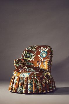 an upholstered chair with a flowered design on it's back and arms