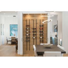 a dining room table and chairs with wine racks on the wall